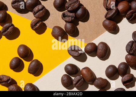 Kaffeebohnen von oben auf einem Hintergrund in verschiedenen Farben gesehen Stockfoto