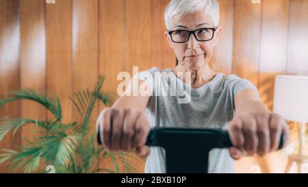 Ältere Frau misst Körperzusammensetzung mit digitaler Waage Stockfoto