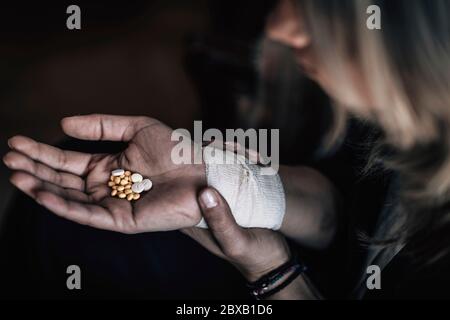 Suizidfrau hält Anzahl von Pillen in der Hand Stockfoto