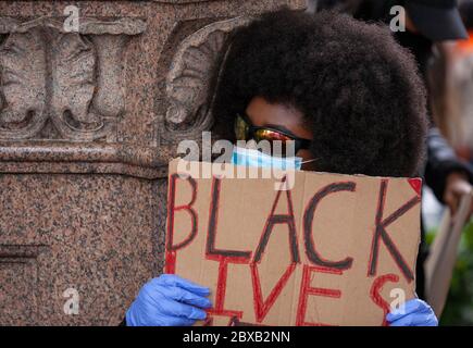 Ein kleiner Junge mit afro-Frisur, der PSA und Sonnenbrille trägt, hält ein Schild mit den "SCHWARZEN LEBEN" vor dem BLM UK Protest auf dem Parliament Square in London Stockfoto