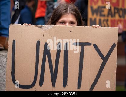 Mädchen hält ein selbstgebautes Pappschild mit der Aufschrift "EINHEIT" auf dem BLM-Protest auf dem Parliament Square hoch. London, England, Großbritannien Stockfoto