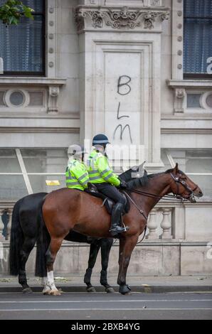 Zwei Polizisten zu Pferd vor BLM-Graffiti. Whitehall, London, England, Großbritannien Stockfoto