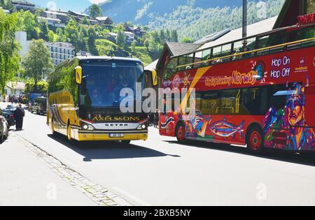 Eine Setra S515HD, betrieben von Axelssons aus Vasteras, Schweden, wird in Geiranger, Norwegen, gesehen, vorbei an einem City Sightseeing MANN Unvi Urbis Doppeldeckerbus. Stockfoto