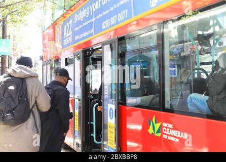 Einsteigen in einen Bus an der Mitteltür, während der Coronavirus-Pandemie, um den Fahrer zu schützen, in London, Großbritannien Stockfoto
