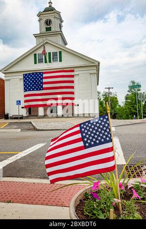 Das Barre, Massachusetts Town Hall mit einer sehr großen amerikanischen Flagge, die an der Vorderseite des Rathauses hängt. Stockfoto