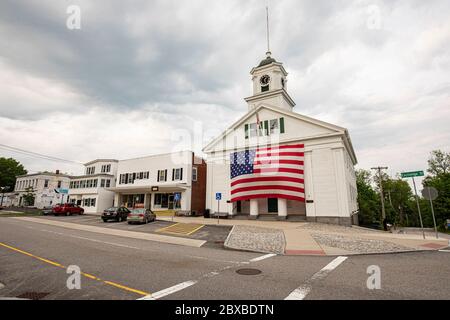 Das Barre, Massachusetts Town Hall mit einer sehr großen amerikanischen Flagge, die an der Vorderseite des Rathauses hängt. Stockfoto