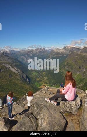 Touristen erkunden Dalsnibba, ein Berg 1500 m über dem Meeresspiegel und mit Blick auf die Kreuzfahrtschiffe in Geirangerfjord, Norwegen. Stockfoto