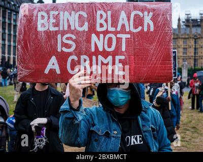 London, Großbritannien. Juni 2020. Ein Protestant hält ein Plakat mit der Aufschrift "Schwarz sein ist kein Verbrechen" während des Black Lives Matter Protests auf dem Parliament Square in Lardo. In Erinnerung an George Floyd, der am 25. Mai in Polizeigewahrsam in der US-Stadt Minneapolis getötet wurde. Quelle: Yousef Al Nasser/Alamy Live News. Stockfoto