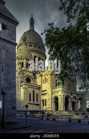 Paris, Frankreich - 12. Mai 2020: Romantischer Pariser Sonnenuntergang über der Basilika Sacre Coeur auf dem Hügel Montmartre. Bildunterschrift 'cor jesu sacratissimum' - Sa Stockfoto