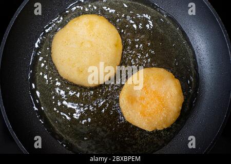 Arepas in einer Pfanne mit Öl. Draufsicht. Kochen venezolanischen Speisen. Stockfoto
