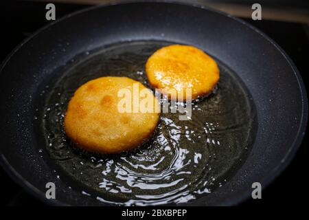 Venezolanischen arepas Rezept. Braten in einer Pfanne mit Öl. Stockfoto