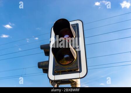 Ampel vor dem Bahnübergang mit einer roten Ampel vor nahenden Zügen warnen. Stockfoto