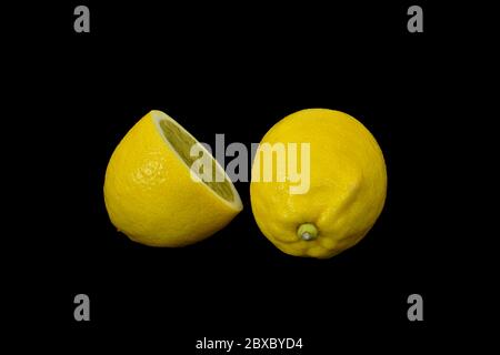 Reifes Gelb und frische Zitrone. Zitronen isoliert auf schwarzem Hintergrund. Stockfoto