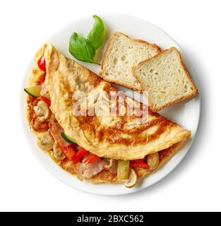 Omelette mit Gemüse und Speck auf weißem Teller auf weißem Hintergrund isoliert gefüllt, Draufsicht Stockfoto