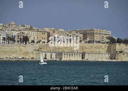 Blick auf den Quarry Wharf vom Grand Harbour. Die Uferpromenade ist im Vordergrund, die hellbraune Architektur im Hintergrund Stockfoto