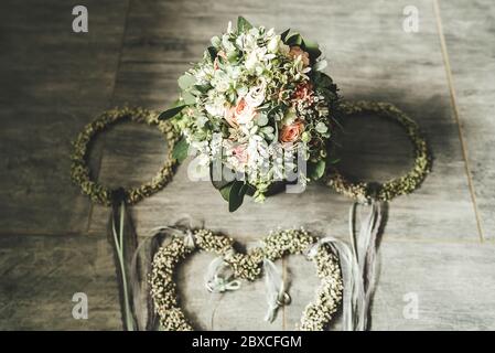 Brautstrauß mit Blumenschmuck arrangiert. Blumen liegen auf grauem Fliesenboden. Konzept für Hochzeitstag. Stockfoto
