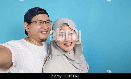 Portait von glücklich asiatischen muslimischen Paar macht Selfie und lächelnd, Mann und Frau umarmt voller Liebe, Familienkonzept Stockfoto