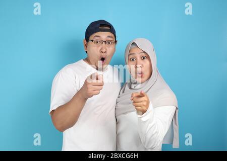 Portait von glücklich asiatischen muslimischen Paar lächelnd und zeigt auf Kamera, Mann und Frau umarmt voller Liebe, Familienkonzept Stockfoto