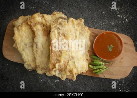 Gorengan tempe, indonesischer gebratener tempe-Snack, serviert mit Sambal- oder Chilisauce und Chilischote, serviert auf Holzplatte Stockfoto