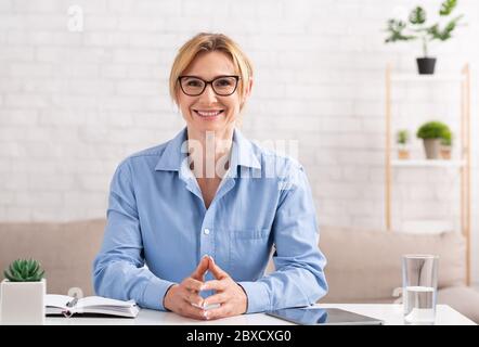 Moderne Beruf ist freiberuflich. Frau am Arbeitsplatz im Wohnzimmer Stockfoto
