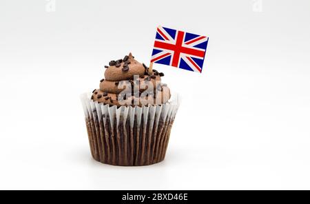 Ein butterhaltiger Schokoladenchip Cupcake mit einem Zahnstocher der britischen Flagge, der auf Weiß isoliert ist Stockfoto