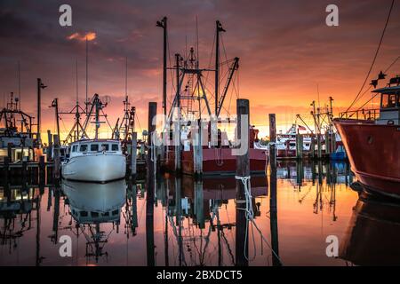 Weitaufnahme der Fischereiflotte im Viking Village, während sich ein wunderbarer Sonnenaufgang entfaltet Stockfoto