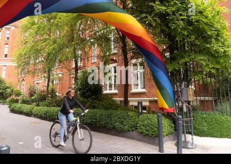 Hotelgäste fahren ihr Fahrrad durch das Regenbogentor des St. Ermin's Hotel Central London an der Caxton Street, St James's Park, während UK Coronavirus lo Stockfoto