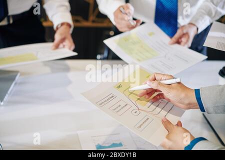 Nahaufnahme der Geschäftsfrau beim Lesen des Dokuments mit dem Plan der Maßnahmen zur Krisenbewältigung Stockfoto