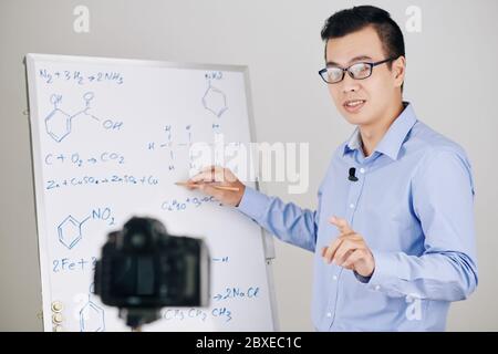 Lehrer der Wissenschaftsschule im Büro mit der Kamera, wenn er Chemieunterricht für seine Schüler aufzeichnet Stockfoto