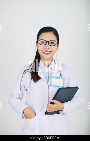 Porträt von glücklichen jungen asiatischen Ärztin mit weißen toothy Lächeln hält Tablet-Computer Stockfoto