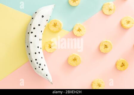 , weiße Bananenschalen auf rosa, lila Hintergrund, Einschluss Konzept Kunst Stockfoto