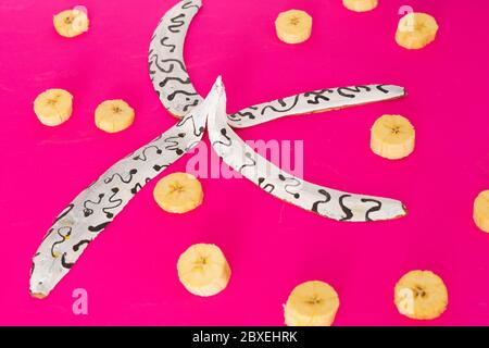 Blau, weiß rosa gefärbte Bananenschalen auf rosa, lila Hintergrund, Inklusion Concept Art Stockfoto