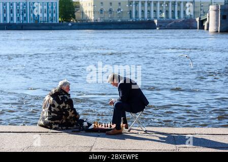 Russland, Sankt Petersburg, 23. Mai 2020: Zwei Männer spielen Schach auf dem Damm Stockfoto