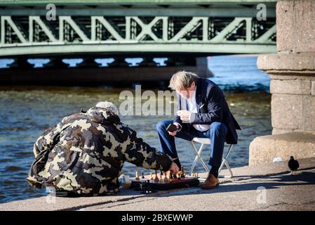 Russland, Sankt Petersburg, 23. Mai 2020: Zwei Männer spielen Schach auf dem Damm Stockfoto