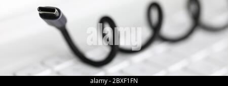 Das Kabel für die Verbindung mit dem Gerät liegt auf der Tastatur Stockfoto