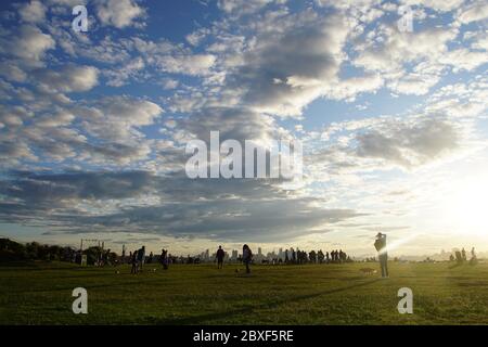 Menschen auf Sydneys Dudley Page Reserve warten darauf, dass die Sonne über der Skyline der Stadt aufgeht Stockfoto