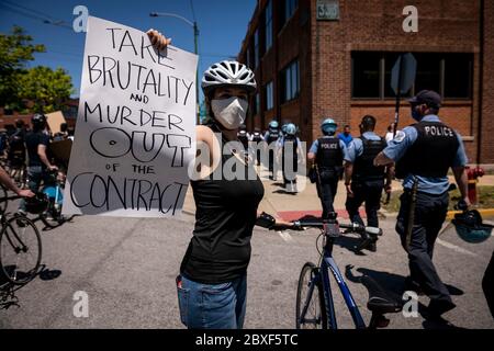 Chicago, USA. Juni 2020. Ein Demonstrator hält ein Schild hoch, als die Polizei am 6. Juni 2020 in Chicago vorbeikommt. Schätzungsweise 20,000 Demonstranten kamen am Samstag zum sogenannten 'Chicago March of Justice' in Chicago, um Gerechtigkeit für George Floyd zu fordern. Kredit: Chris Dilts/Xinhua/Alamy Live News Stockfoto