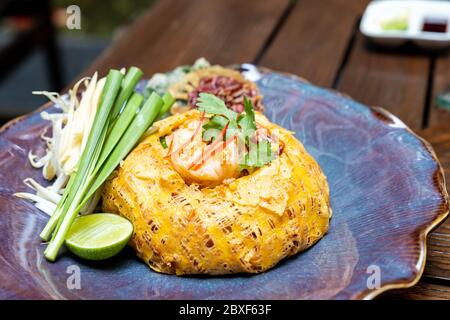 Padthai, Thai Stil Pfanne gebratene Reisnudel mit Tamarindensoße, servieren mit gegrillten Tigergarnelen Abdeckung mit Omelette.Thai Gourmet-Küche Rezept Restaurant Stockfoto