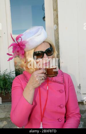 Die als Lady Penelope gekleidete Konkurrentin entspannt sich während des Beaujolais-Laufs 2011 an einem der Kontrollpunkte in Burgund Frankreich bei einem Kaffee Stockfoto