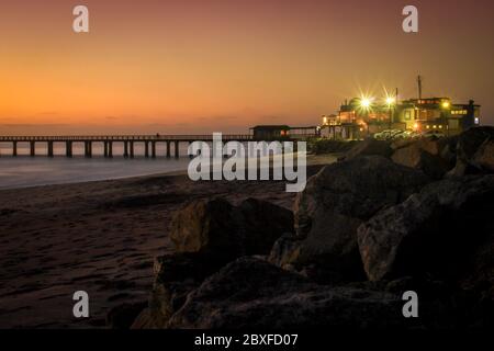 Pier am Atlantik in Swakompund, Namibia. Schöner Sonnenuntergang mit einem hellen Himmel und weichen sanften Wasser und Sand Stockfoto