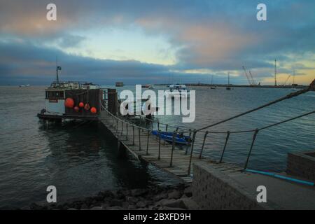 Walvis Bay, Namibia - 25. April 2015: Atlantikküste mit Steg in der Abenddämmerung. Bootsausflüge Stockfoto