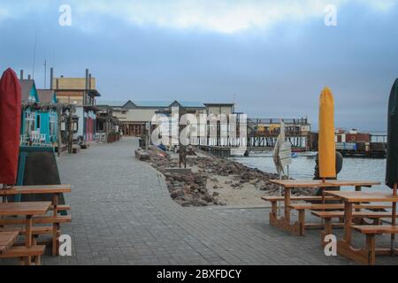 Walvis Bay, Namibia - 25. April 2015: Atlantikküste mit Steg in der Abenddämmerung. Leeres Restaurant am Pier. Stockfoto