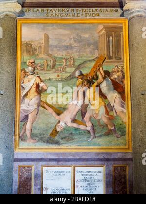 Die Wände sind mit Fresken geschmückt, die die Kreuzigung des Heiligen Petrus im Vordergrund und die Enthauptung des Heiligen Paulus im Hintergrund darstellen - Basilica di Santo Stefano Rotondo al Celio - Rom. Italien Stockfoto