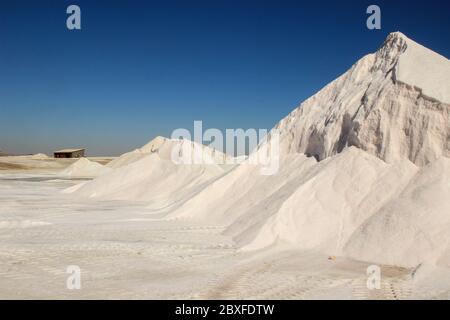 Salzproduktion in einer Fabrik aus dem Atlantischen Ozean an der Küste bei Walvis Bay, Namibia. Berge von Salz. Stockfoto