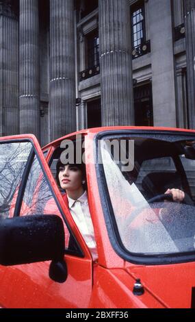 Junge Frau mit ihrem Ford Fiesta Finesse 1986 in London Stockfoto
