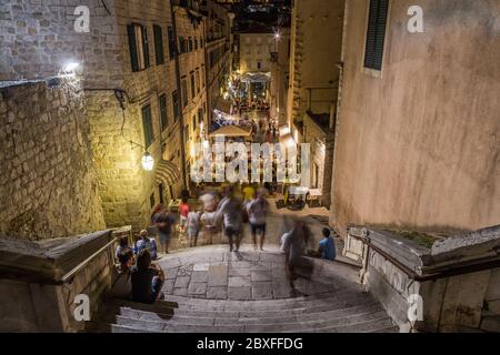 DUBROVNIK, KROATIEN - 11. AUGUST 2016: Blick auf die Straßen von Dubrovnik bei Nacht. Man kann die Menschen und die Außenwelt der Geschäfte und Restaurants sehen. Stockfoto