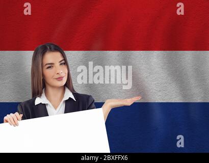 Junge Frau mit weißem Banner und Nationalflaggen Stockfoto