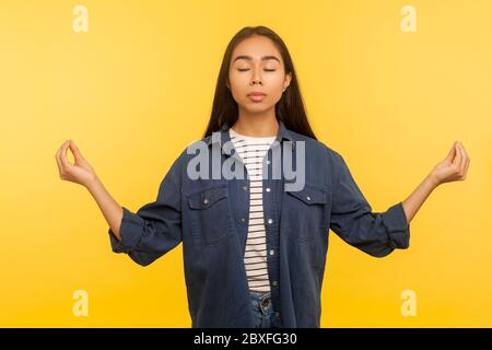 Friedlicher Geist. Porträt einer Frau im Denim-Hemd meditiert mit Mudra-Geste und Gefühl Harmonie Gleichgewicht, Pause zu entspannen, Gedanken konzentrieren Stockfoto