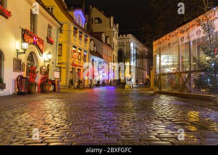 RIGA, LETTLAND - 1. JANUAR 2017: Gebäude am Livu Laukums (Platz) bei Nacht. Zeigt die Außenseite von Gebäuden, Geschäften und Gebäuden. Menschen sind zu sehen Stockfoto