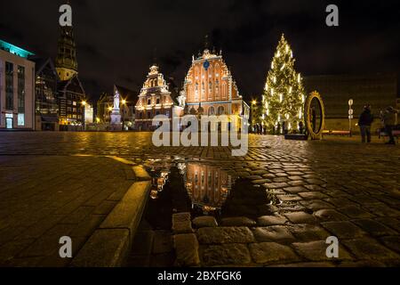 RIGA, LETTLAND - 1. JANUAR 2017: Das Haus der Schwarzhäupter ist während der Weihnachtszeit nachts von außen zu sehen. Menschen sind zu sehen. Stockfoto